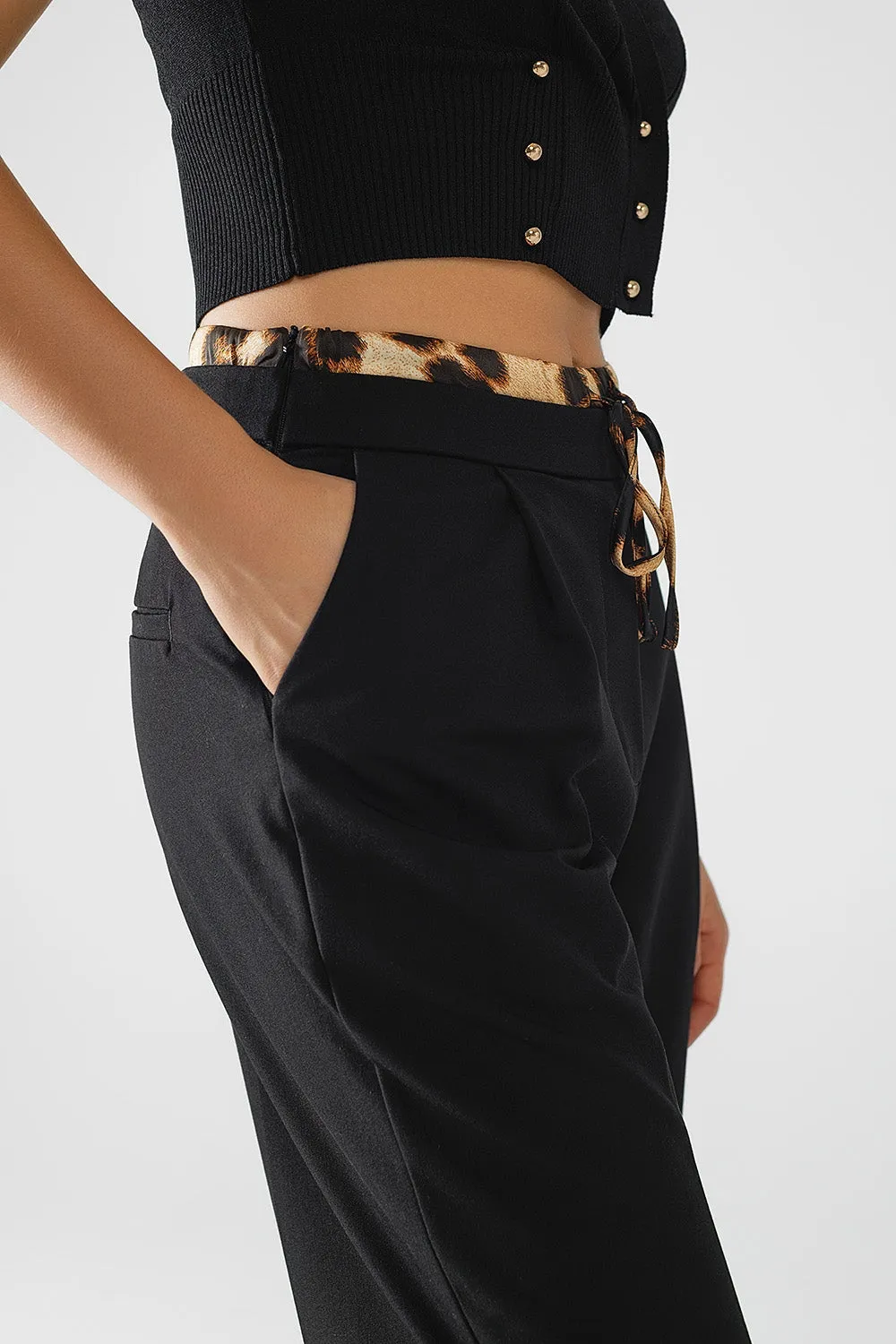 Long black pleated pants with leopard detail at the waist
